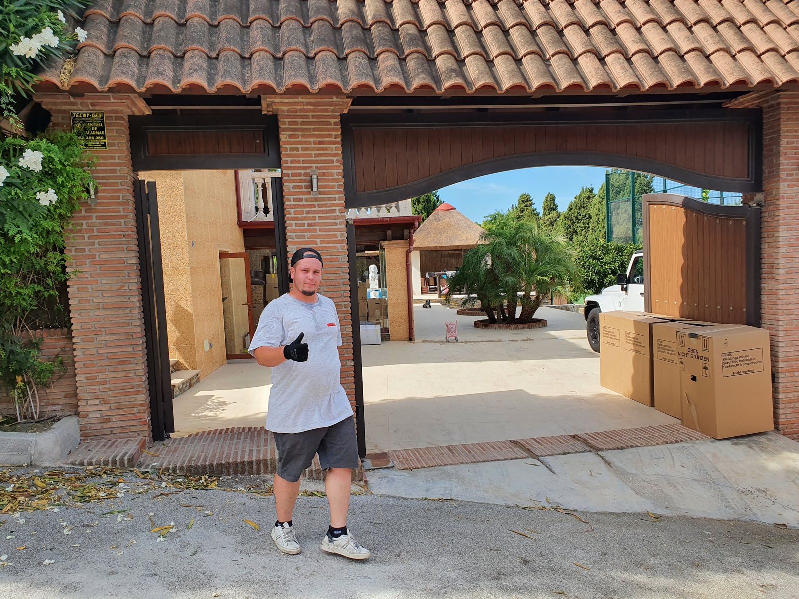 Mitarbeiter mit Umzugskartons vor einem Hoftor