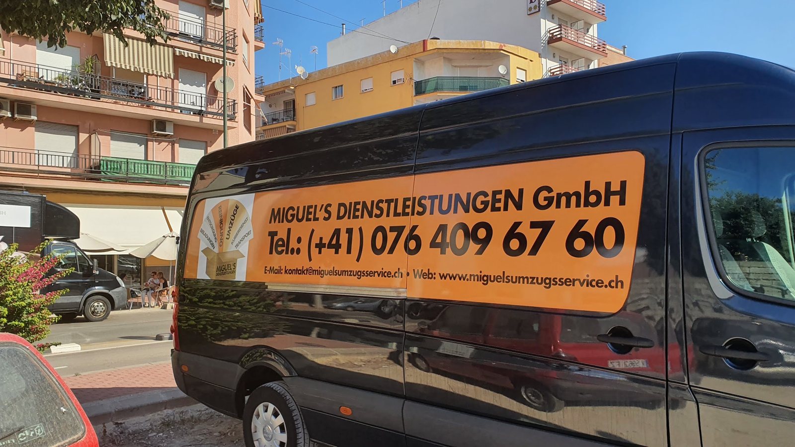 Schwarzer Transporter mit Beschriftung in einer spanischen Strasse