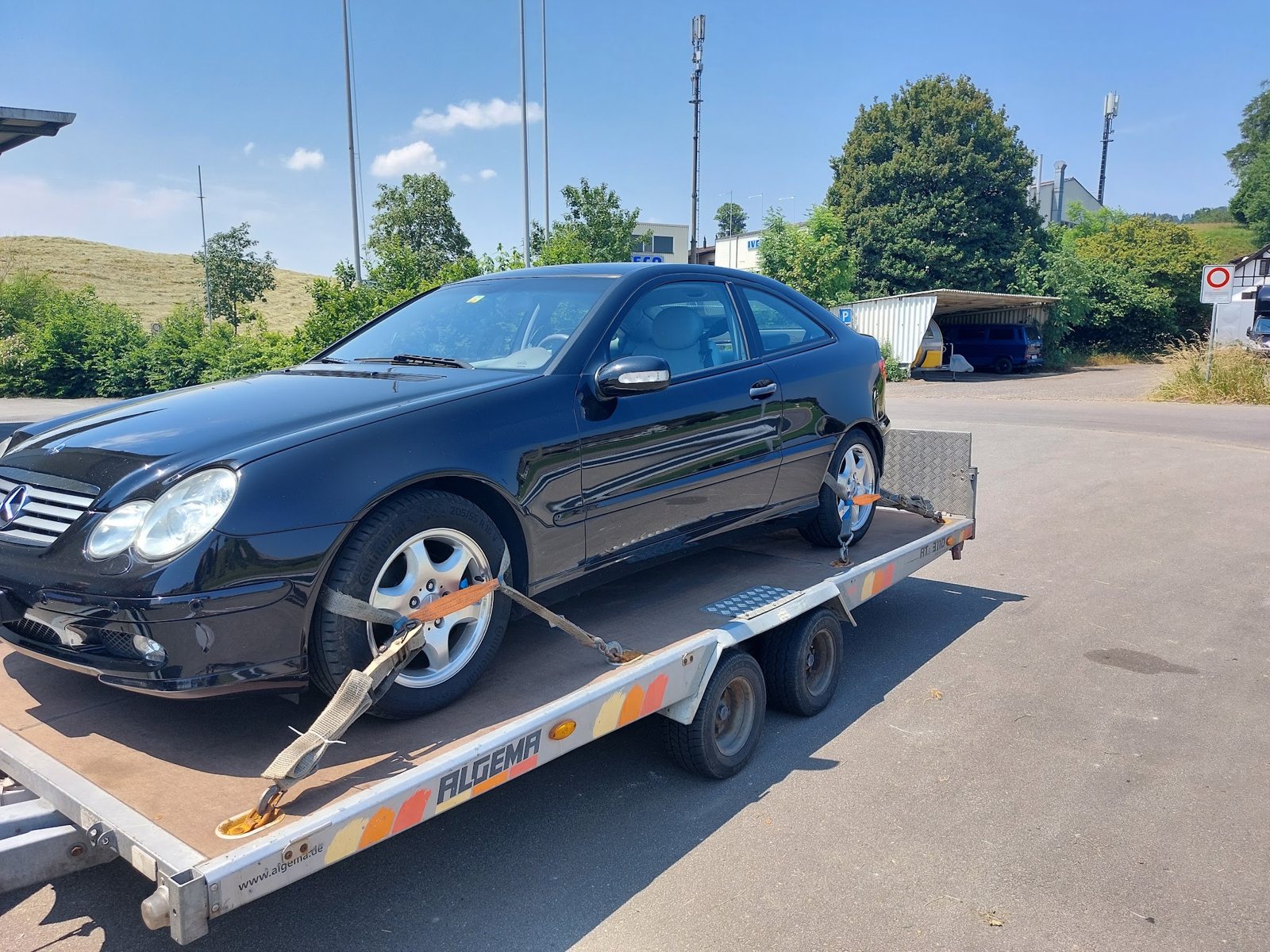 Schwarzes Coupé auf dem Fahrzeuganhänger